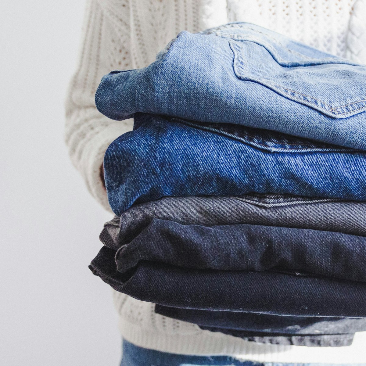 Neatly folded garments held with care